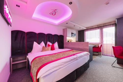 伊施格尔Alp Larain B&B的一间卧室设有一张粉红色天花板的大床