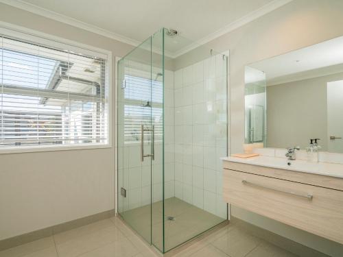 怀蒂昂格Relax on Roseberry - Whitianga Holiday Home的一间带玻璃淋浴和水槽的浴室
