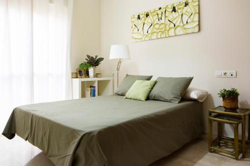 马拉加Apartamento Málaga Jalón的一间卧室配有一张带绿色枕头的大床
