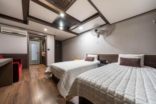 釜山MU Hotel Sasang的一间卧室设有两张床和天花板