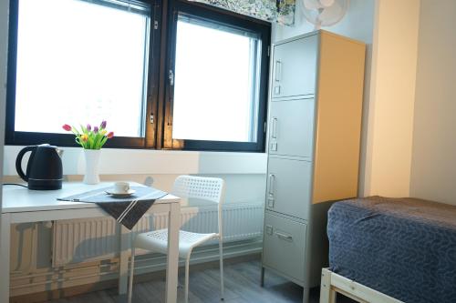 赫尔辛基Inn Tourist Hostel的一间卧室配有书桌、一张床、一张桌子和椅子
