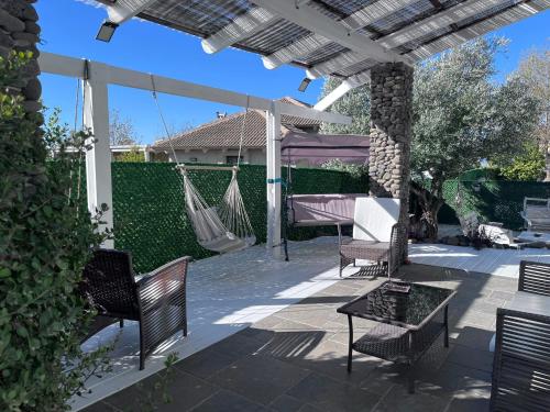 Ani'amאלרון - אירוח בגולן的一个带椅子和吊床的庭院和一座房子