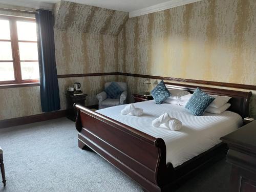 福耶斯Craigdarroch Hotel的一间卧室配有一张带蓝色枕头的大床