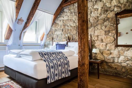 格拉茨Gasthof Lend-Platzl的卧室配有一张石墙内的大床
