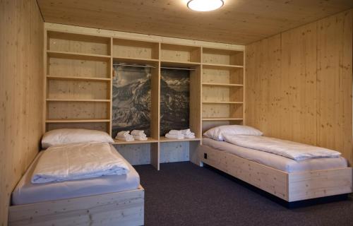 克恩斯Frutt Living的配有木墙和架子的客房内的两张床