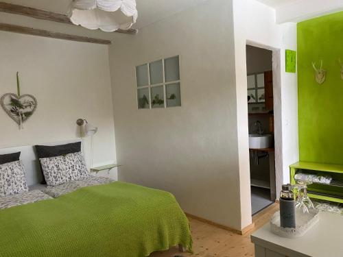 Niederhollabrunn温克勒葡萄花园民宿的卧室拥有绿色和白色的墙壁,配有一张床