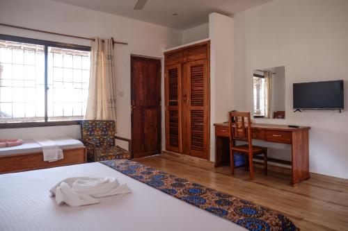 南威Nungwi Heritage Resort的一间卧室配有书桌、一张床和一张书桌