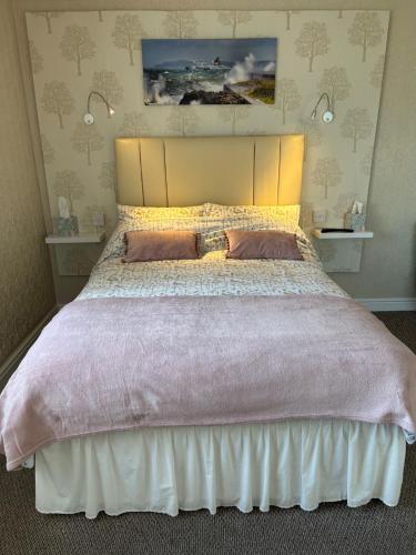 霍利黑德Crossroads的一间卧室配有一张大床和两个枕头