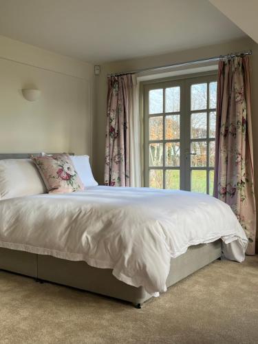 奇平诺顿The Old School, Idbury, OX7 6RU的一间卧室设有一张大床和一个窗户。