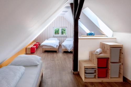 利布韦尔达矿泉村Vila Tess的阁楼卧室配有两张床和镜子