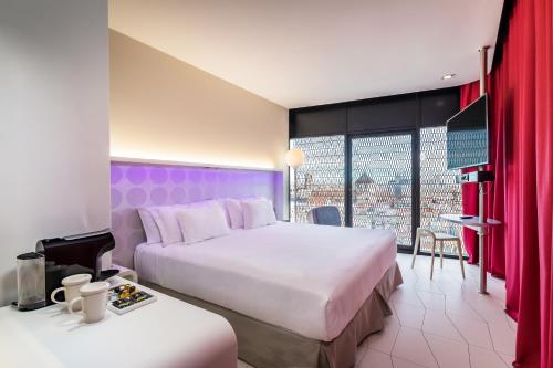 巴塞罗那Barceló Raval的酒店客房,设有两张床,享有城市美景。