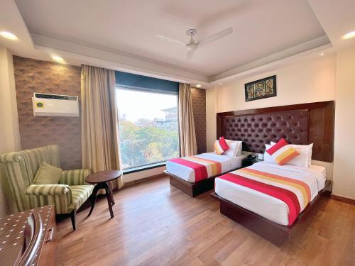 新德里The Grand Orion - Kailash Colony的酒店客房设有两张床和窗户。