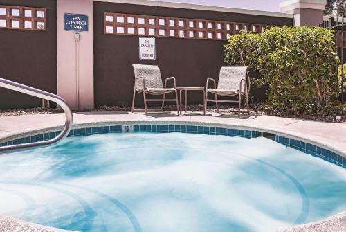 拉斯维加斯拉斯维加斯苏摩林特拉昆塔套房酒店的一个带椅子和桌子的小型游泳池