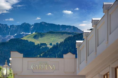 奥蒂塞伊Gardena Grödnerhof - Hotel & Spa的背景为酒店卡拉罗尔的标志,山峰