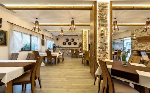 UstinaComplex YustinaVillas的餐厅设有木桌和椅子,拥有砖墙