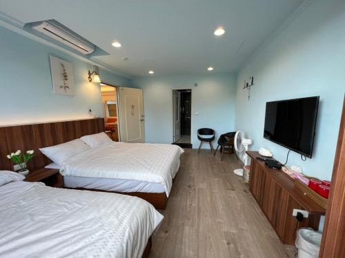 三芝乡旅途中海邊民宿的酒店客房设有两张床和一台平面电视。