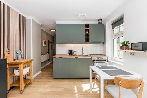 柏林stadtRaum-berlin apartments的厨房配有绿色橱柜和桌子