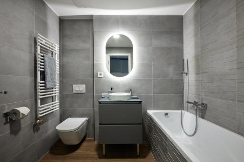 布达佩斯The Amberlyn Suite Hotel的一间带水槽、浴缸和卫生间的浴室