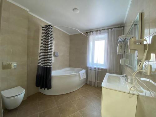 彼得罗巴甫洛夫斯克Skif HOTEL & SPA的带浴缸、卫生间和盥洗盆的浴室