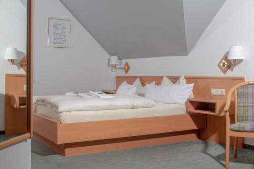 Neuenkirchen-Vörden克鲁斯祖姆霍罗托酒店的一间卧室配有一张带桌子和椅子的床