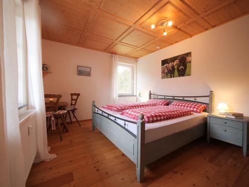 WeitnauFerienwohnung Böck, Wengen im Allgäu的一间卧室配有一张红色棉被的床