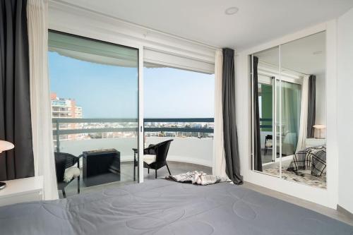 波尔蒂芒Vista Bonita with views on the ocean and the hills的一间卧室设有一张床,享有阳台的景色