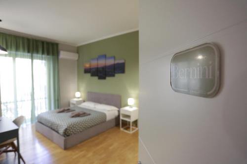 那不勒斯Vomero Maison的一间卧室配有一张床,墙上配有电视