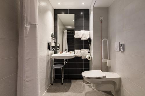 克莱蒙费朗克莱蒙费朗中心假日酒店的白色的浴室设有水槽和卫生间。