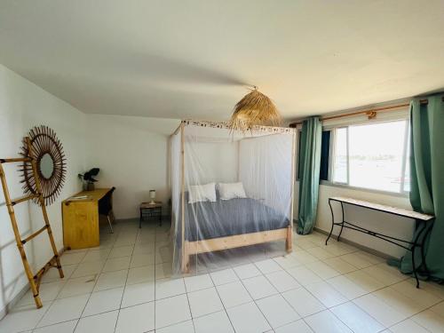 达喀尔La Cabane du Pêcheur Atlantic Evasion的一间卧室配有一张带蚊帐的床