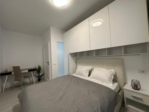 雅西Luxury New Apartments Centru的一间卧室配有一张带白色橱柜的床和一张书桌。