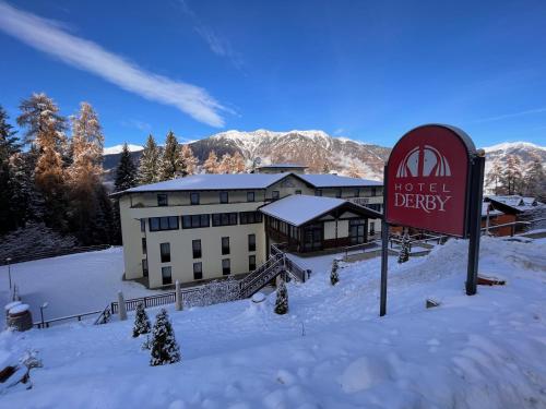 佛加里达Hotel Derby的雪地里的一个酒店,前方有一个标志