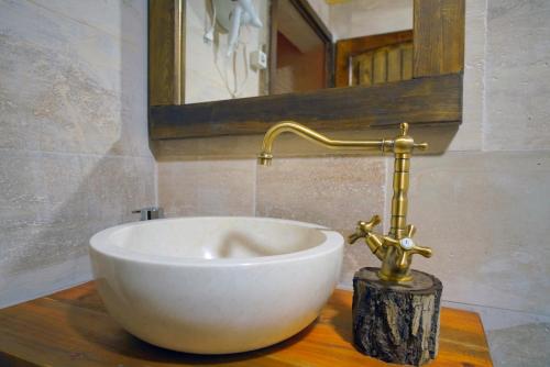 内夫谢希尔Babili Cappadocia Cave Hotel的浴室的木制柜台上有一个白色的碗水槽