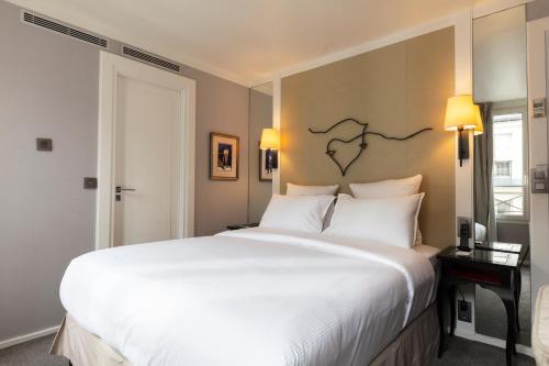 巴黎维拉玛当酒店 的卧室配有带白色枕头的大床