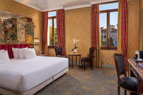 威尼斯NH Collection Grand Hotel Palazzo Dei Dogi的配有一张床和一张书桌的酒店客房