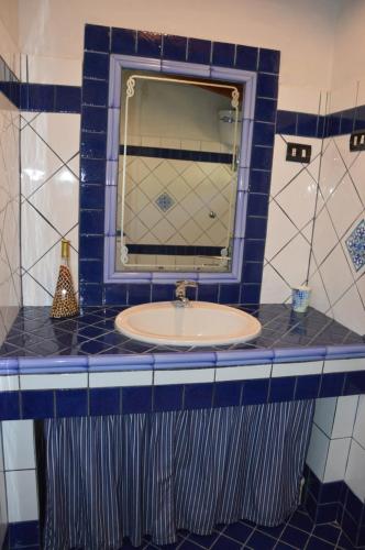 贡内萨Giardino degli Ulivi的一间带水槽和镜子的浴室