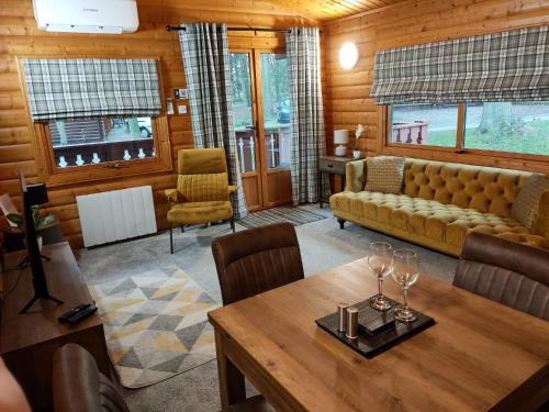劳斯Parkwood Lodge的客厅配有沙发和桌子