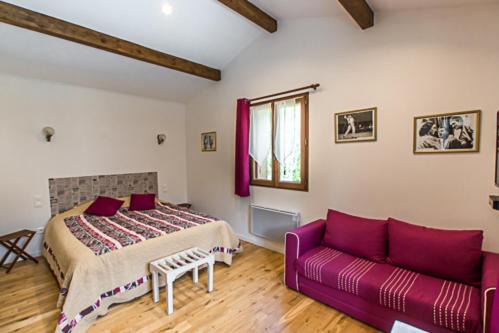 Bajamont菲绸嘉德培尔住宿加早餐旅馆的一间卧室配有一张床和一张紫色沙发