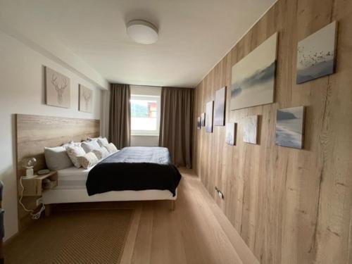 卢捷纳普德克利诺夫琴KLINOVEC APARTMENTS LUXURY的一间卧室设有一张大床和木墙