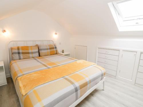 波特马多克Cartref Clyd 55的白色卧室设有床和天窗