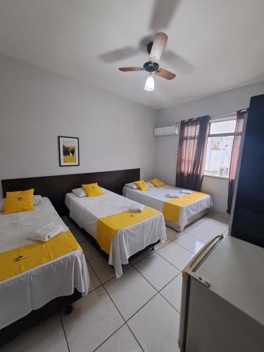 库亚巴Hotel Panorama, Cuiabá的客房设有两张床和吊扇。