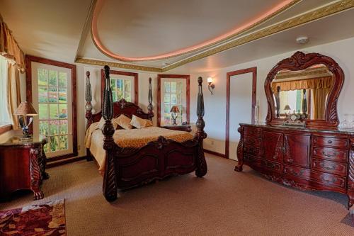 圣阿加瑟莫奥克斯内特斯日维酒店的一间卧室配有一张床和一面大镜子