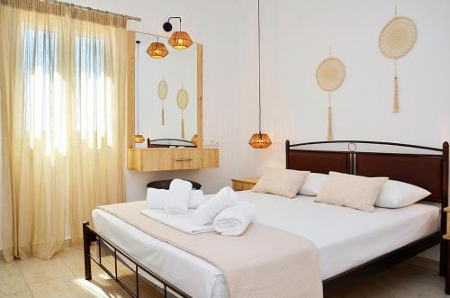 考弗尼西亚Louros rooms的一间卧室配有两张床和白色毛巾。