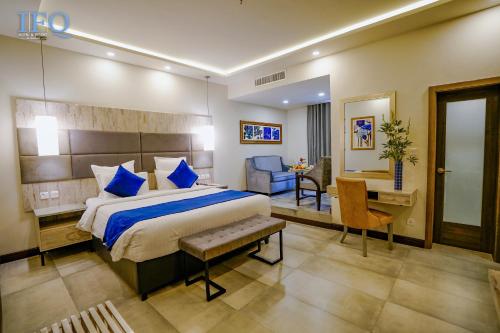 伊斯兰堡IFQ Hotel & Resort的酒店客房设有一张大床和一张书桌。