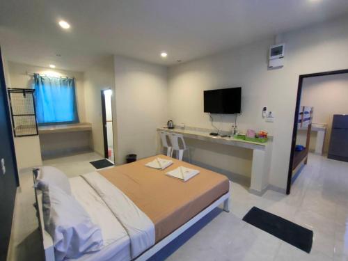 SadaoBanana Resort Sadao的一间卧室配有一张床和一张书桌及电视