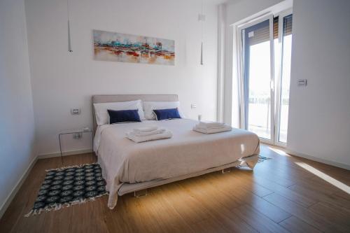 巴里Rossani Suites&Aparts的白色的卧室设有一张大床和一个大窗户