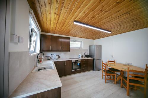 普洛德洛莫斯Legacy 1930s的厨房设有桌子和木制天花板