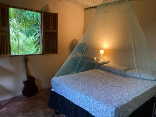 伊塔卡雷Casa Vila Camboinha的一间卧室配有一张带蚊帐的床