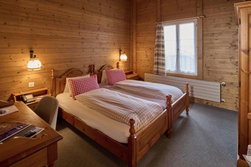 维尔德斯韦尔巴伊兰贝尔酒店的木制客房内的一间卧室,配有一张床