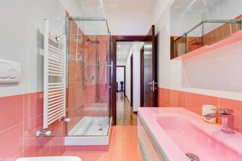 罗马Exclusive Apartment in Eur Lake的粉红色的浴室设有淋浴和水槽