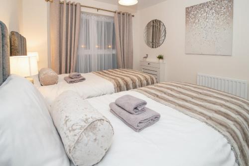 斯蒂夫尼奇Stunning 2-Bed Apartment in Stevenage, Sleeps 5 with free Private Parking的卧室内的两张床,配有毛巾
